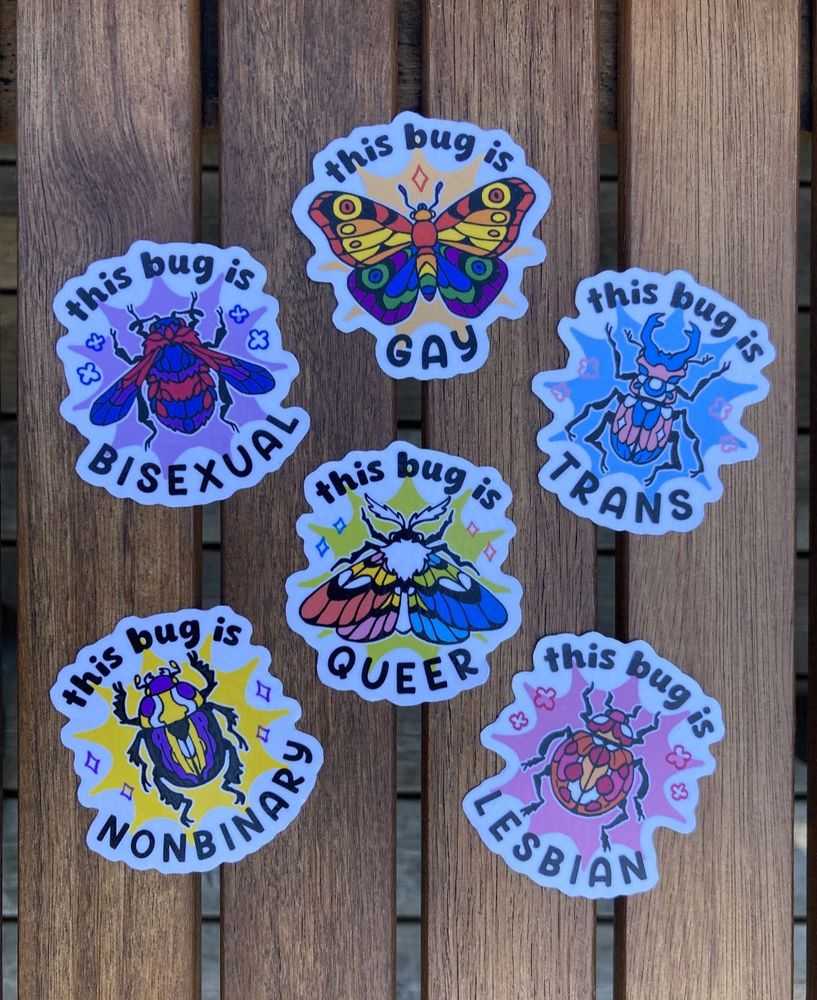 A photo of 6 stickers featuring different kinds of bugs/insects in pride flag colors. Non-binary enby beetle, queer moth, lesbian ladybug, bisexual bee, trans horned beetle and gay butterfly.