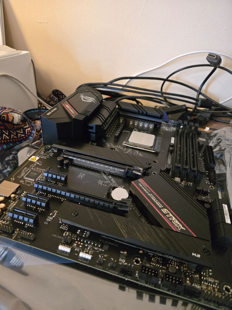 The shiny new motherboard, processor already installed, lies waiting.
