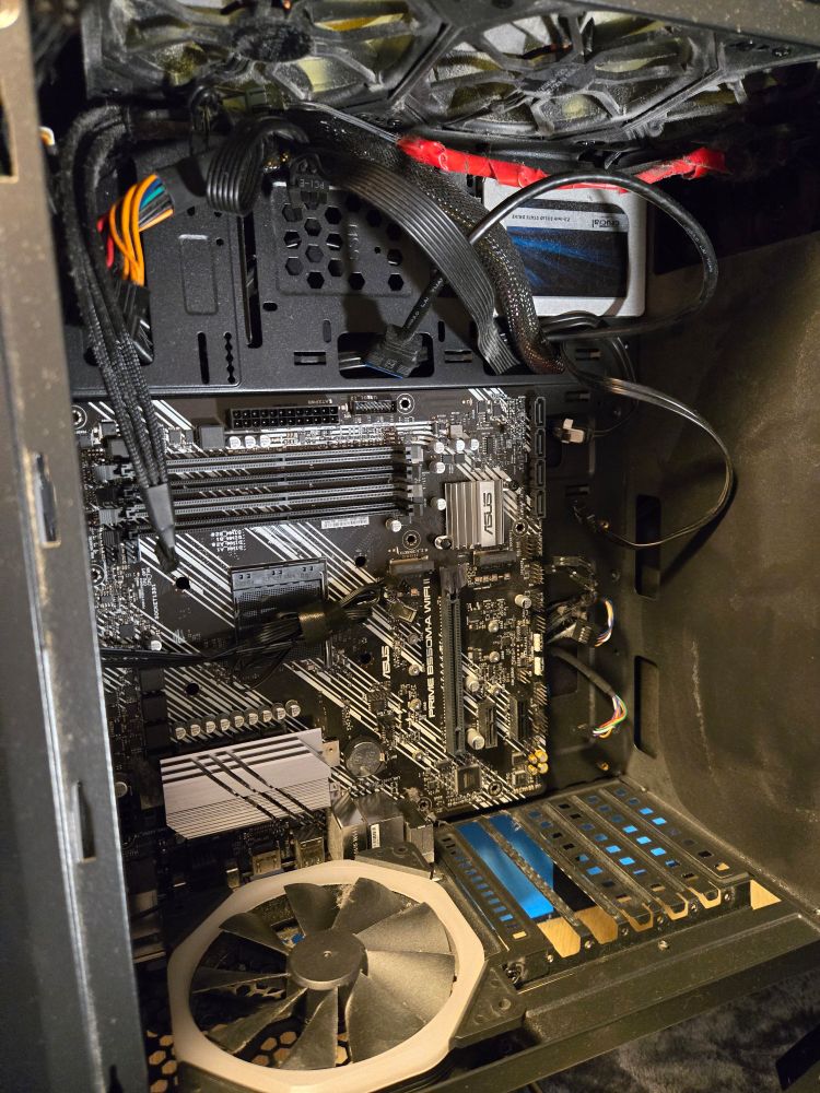 The inside of a rather scruffy PC case, old motherboard in place 