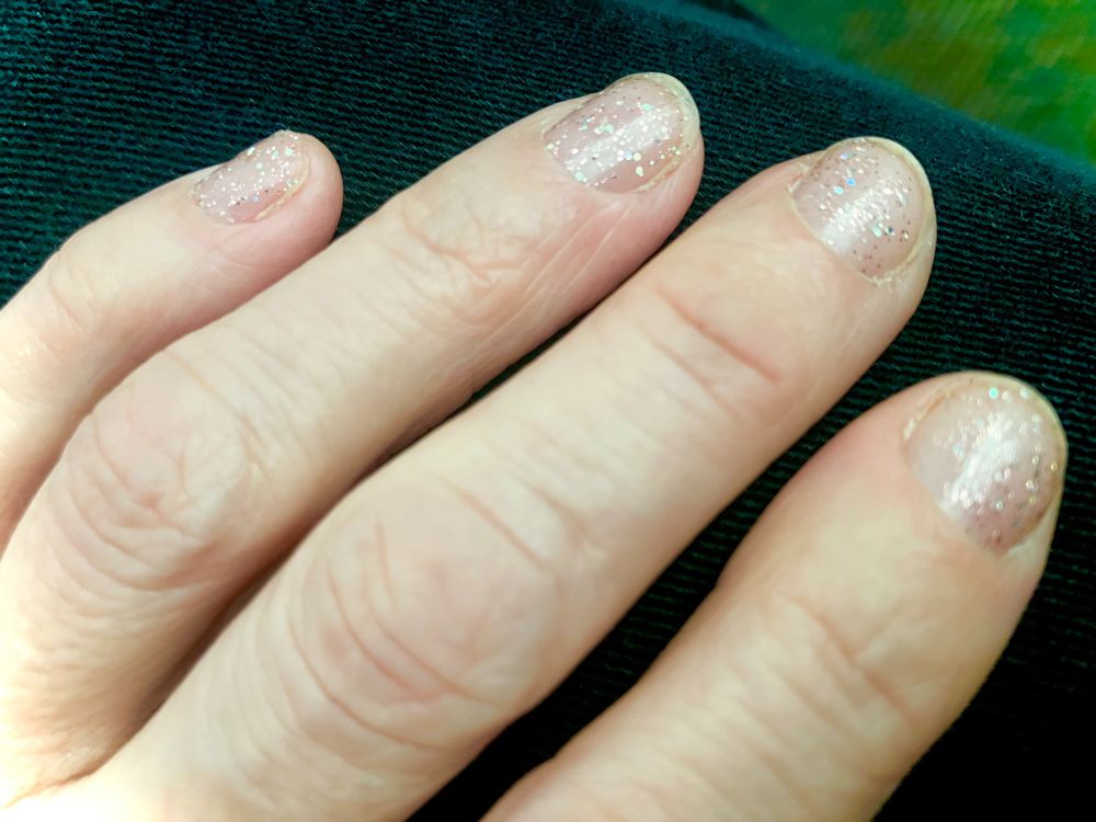 a woman's left hand with glittery nails