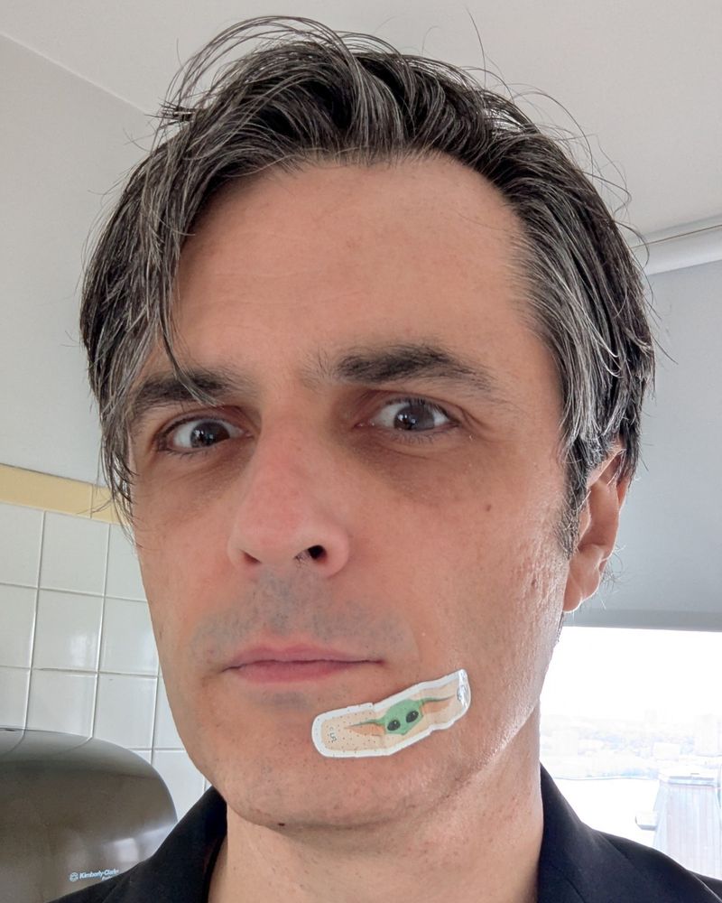 Man with a Grogu band-aid covering his shaving injury.