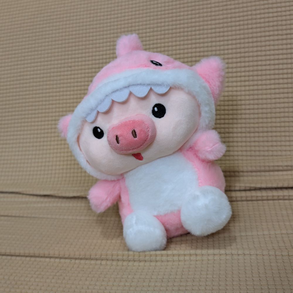 A cute plushie pig in a shark costume.