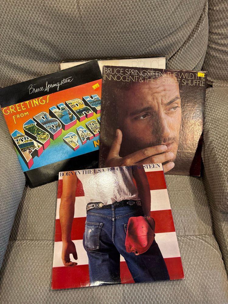 Three album covers, all by Bruce Springsteen: greetings from Asbury Park, Born in the USA, and the Wild, the Innocent, and the E Street Shuffle.