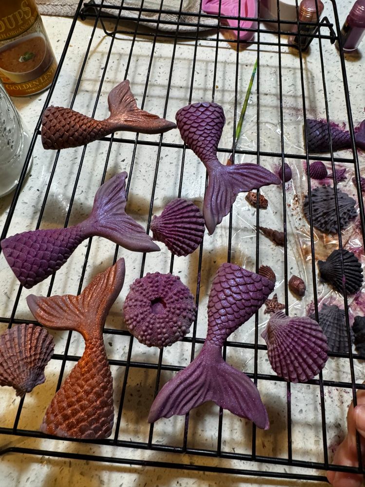 An assortment of purple, glittery, edible mermaid tails and shells. 