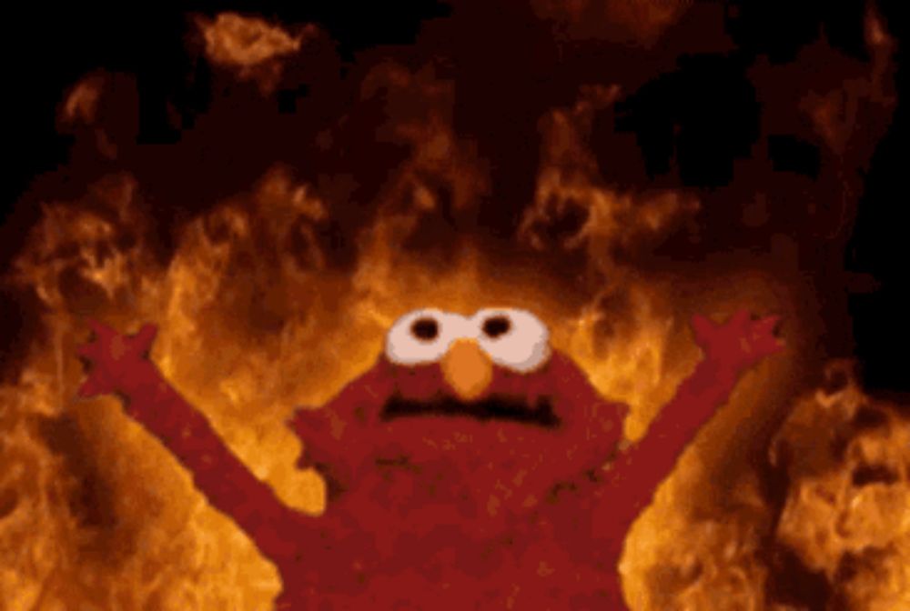 elmo from sesame street is standing in front of a fire