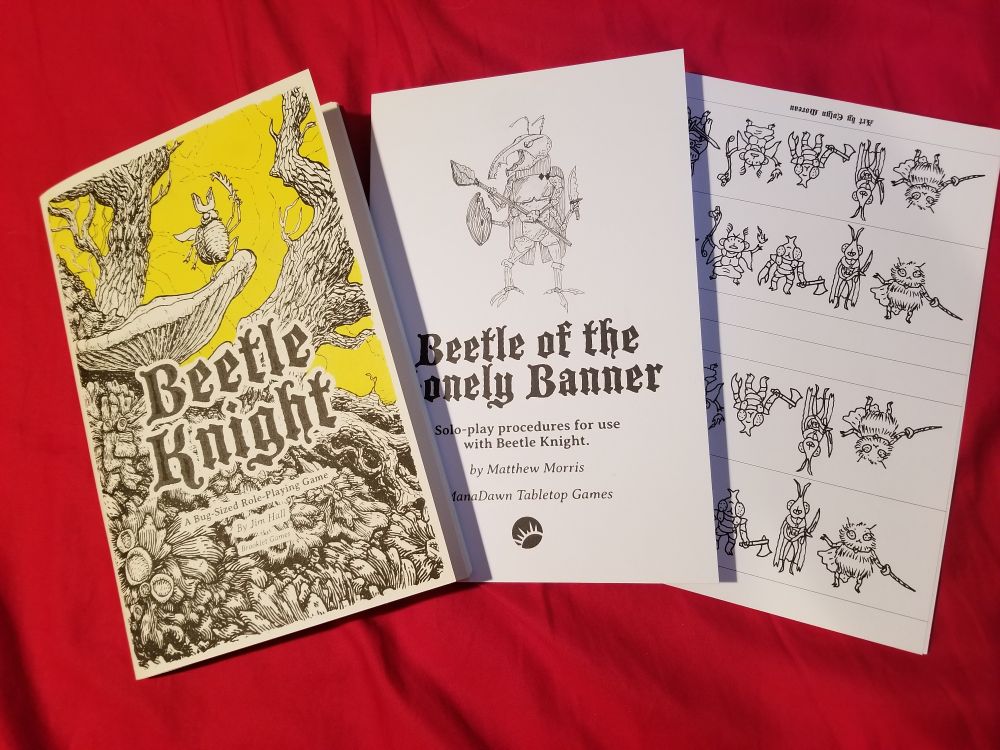 2 zines lying next to one another, alongside a sheet of paper minis. The zine to the left is "Beetle Knight" by Jim Hall ( @brookletgames.bsky.social ), the center zine is "Beetle of the Lonely Banner" by Matthew Morris ( @manarampmatt.bsky.social ), & the paper Bugfolk minis are by Evlyn Moreau ( @evlynmoreau.bsky.social )