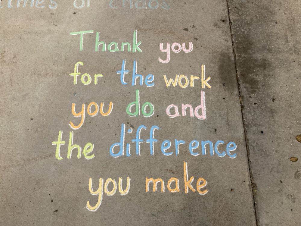 Photo of a sidewalk chalk drawing that says, "Thank you for the work you do and the difference you make."