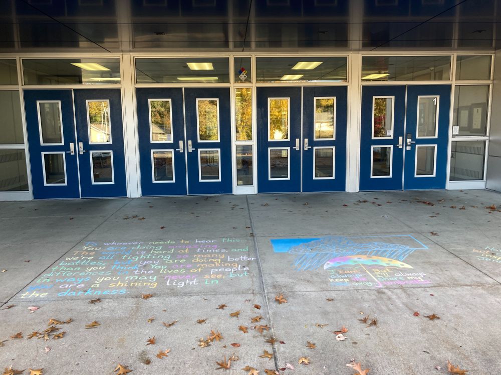 Photo of the sidewalk chalk drawing in front of the school entrance.