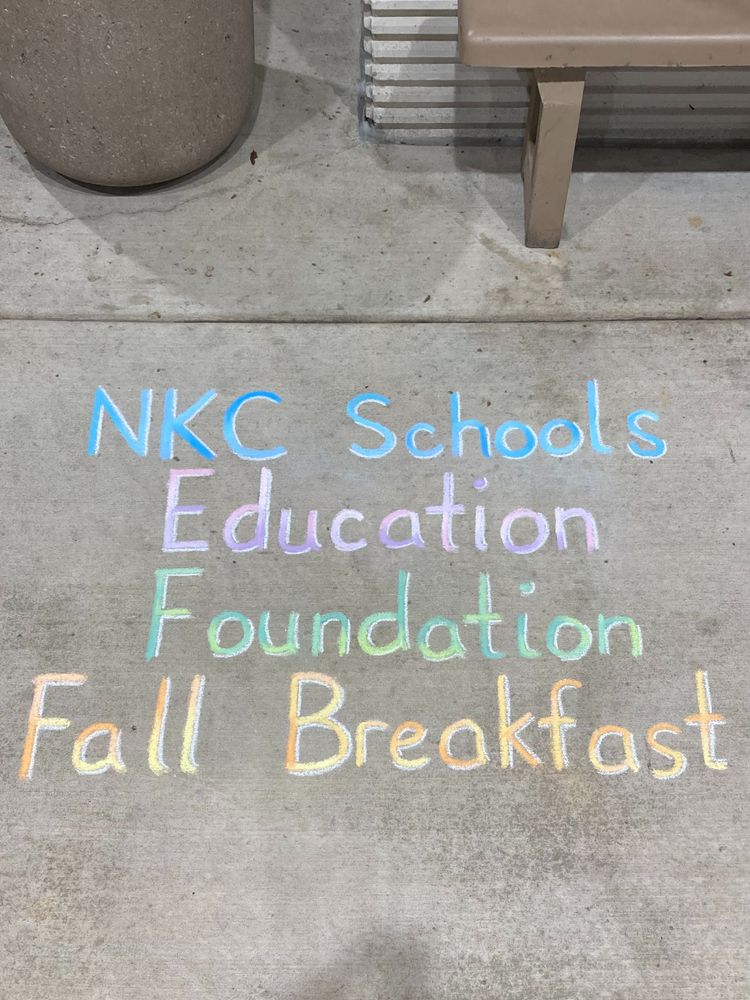 Photo of a sidewalk chalk drawing that says, "NKC Schools Education Foundation Fall Breakfast"