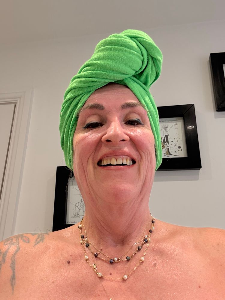 Me wearing a green towel around my hair having got out of the bath