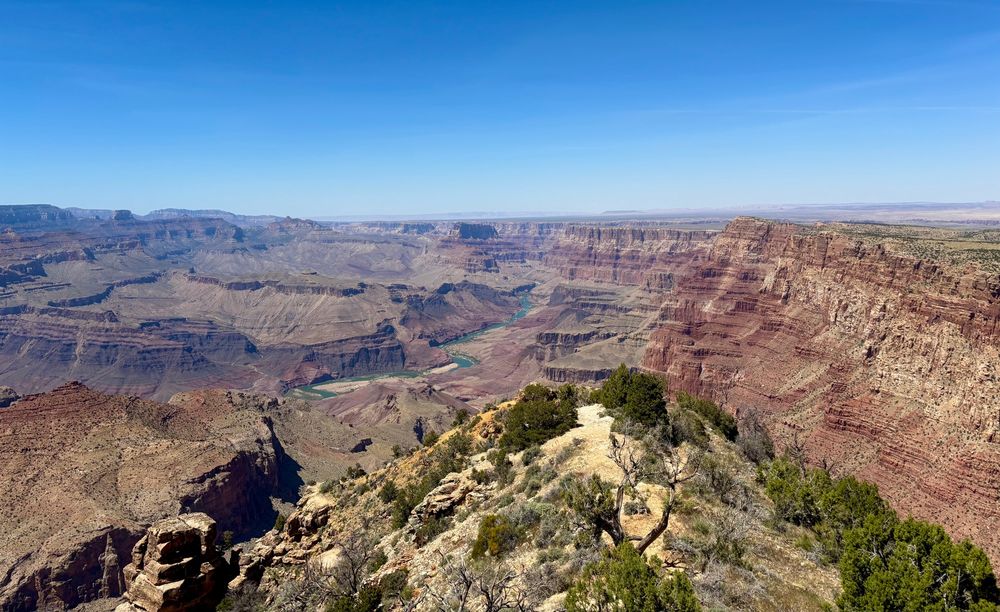 A breathtaking view of the Grand Canyon from the edge of a cliff, showcasing its vastness and intricate rock formations.