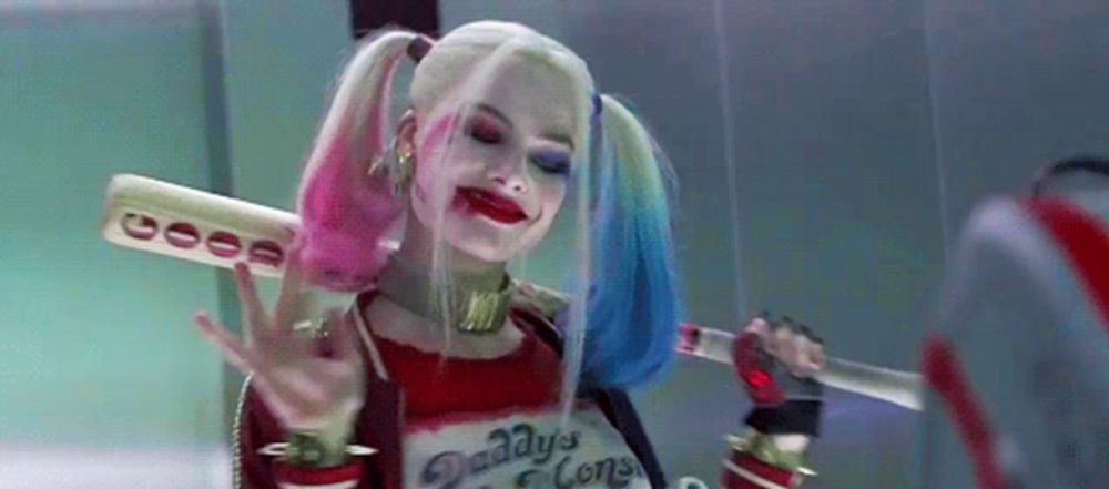 harley quinn from suicide squad is holding a bat and knife .