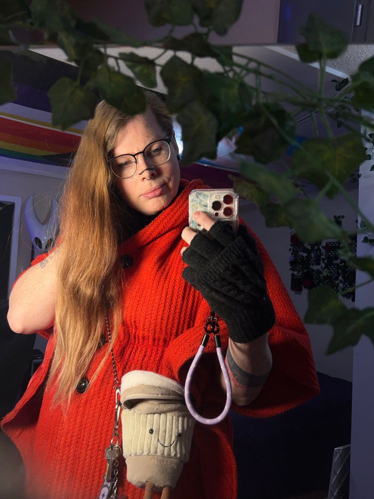 Ready for a walk wearing a red coat and a plush coffee cup purse