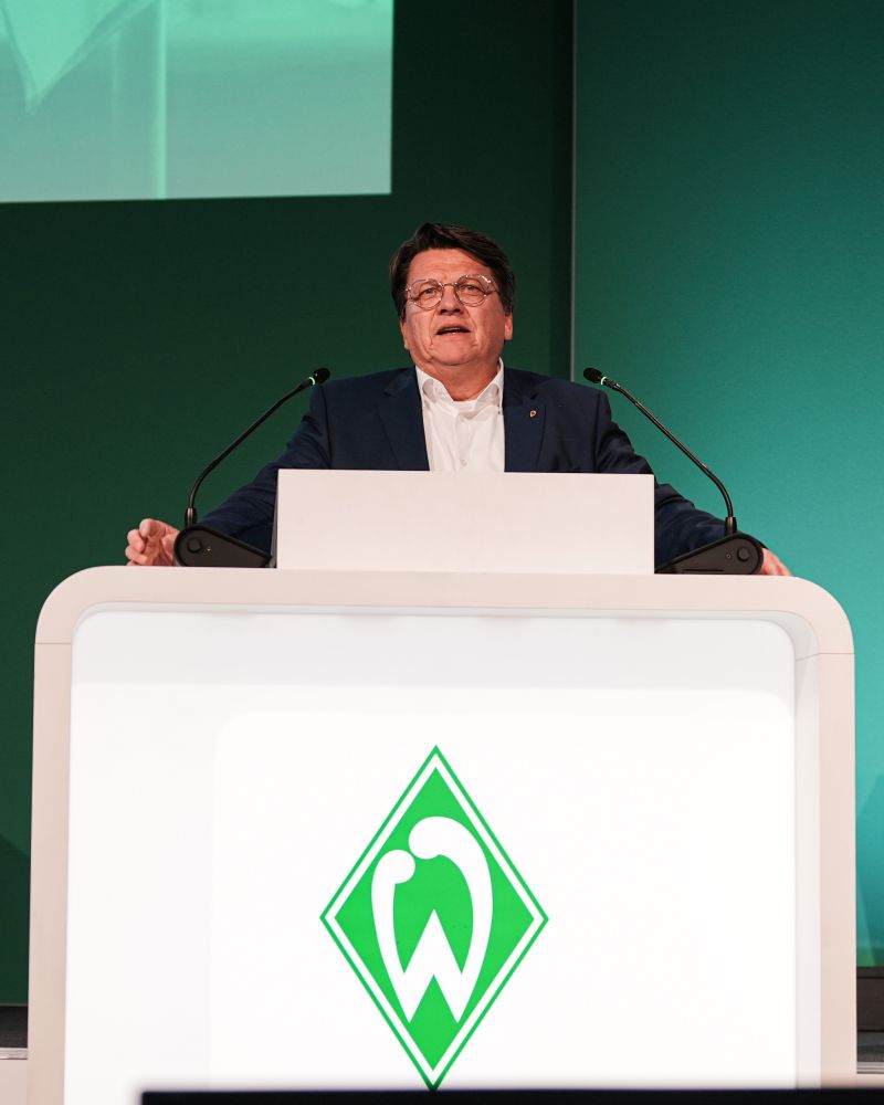 Dr. Hubertus Hess-Grunewald steht an einem Podium und hält eine Rede auf der Mitgliederversammlung.