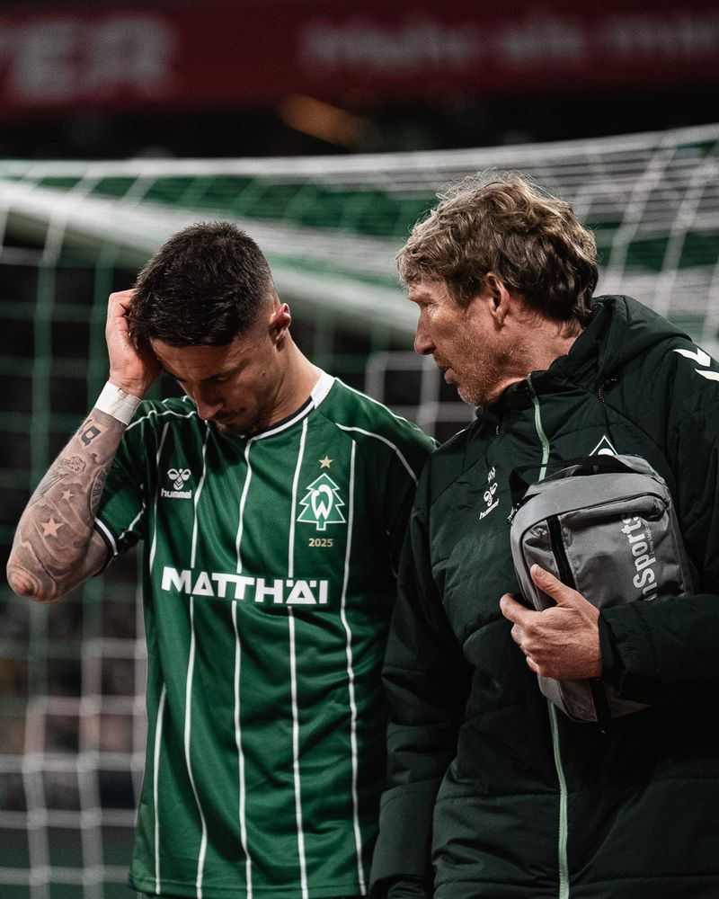 Marco Friedl fässt sich an den Kopf neben dem Mannschaftsarzt.