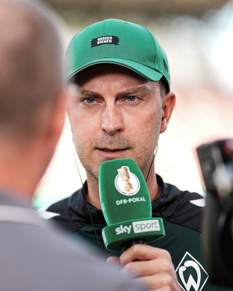 Ole Werner spricht in en grünes DFB-Pokal-Mikrofon.