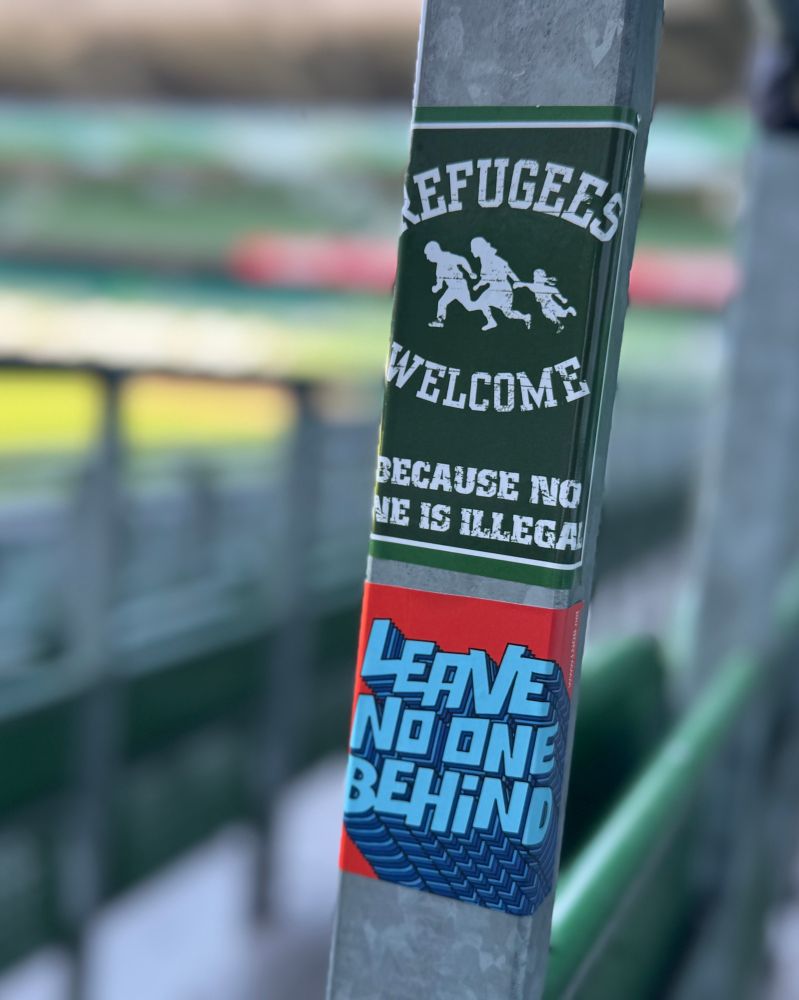 Aufkleber mit Refugees Welcome und Leave no one behind in der Ostkurve