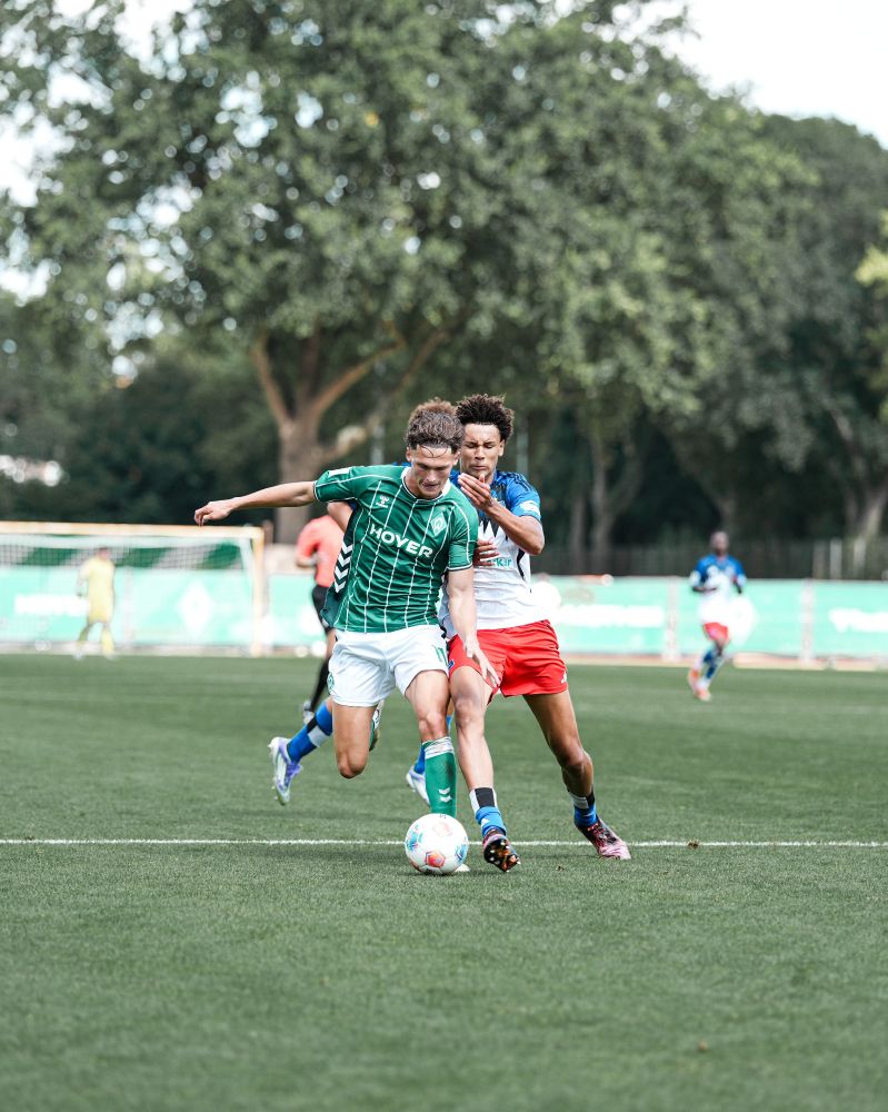 Ein HSV und Werder-U19-Spieler im Zweikampf um den Ball.