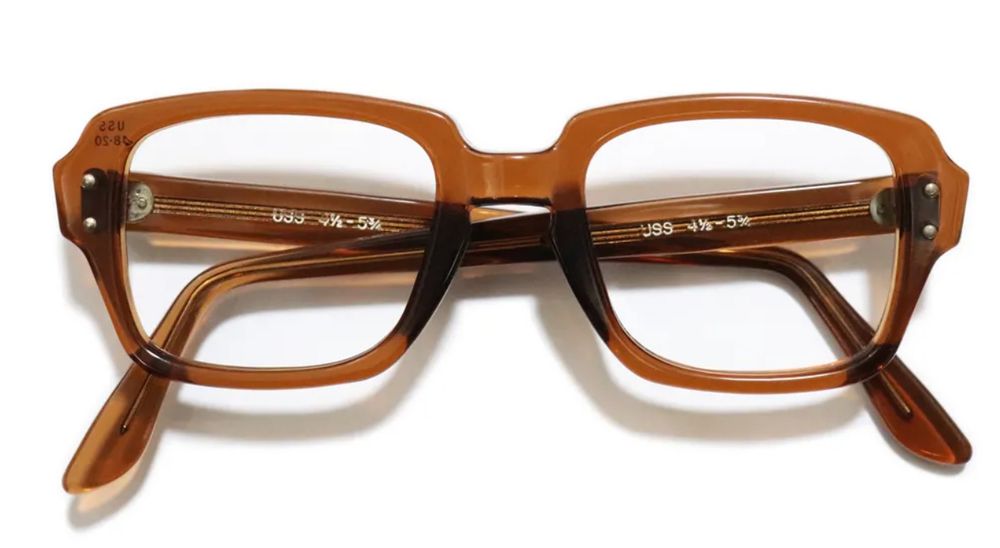 A pair of military issue S9 frames with their legs folded sitting on a white surface.