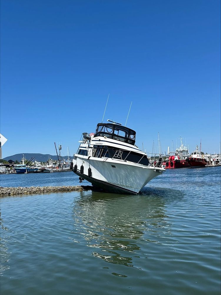 A 40-foot pleasure craft grounded on rocks at Cap Sante Marina, leaning to one side.