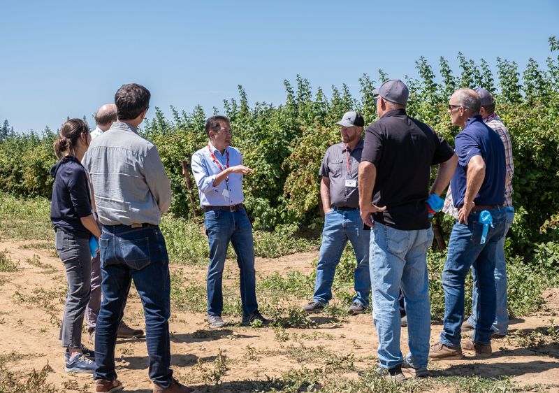 Director Casey Sixkiller talks with Ecology staff and members of the Whatcom Ag Water Board with a field in the background. 