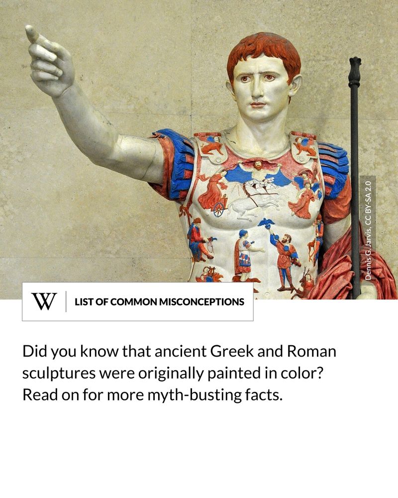 A polychrome reconstruction of the Roman statue, showing Emperor Augustus in a decorated breastplate and red drapery, with his right arm raised and left hand holding a staff. Text says: Did you know that ancient Greek and Roman sculptures were originally painted in color? Read on for more myth-busting facts.