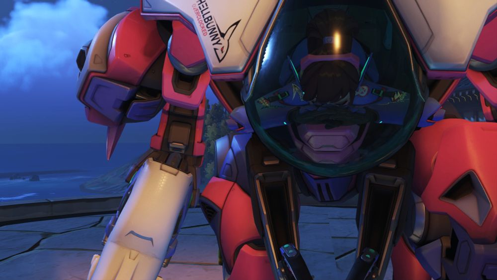 D.va, dressed in her Overwatch 2 default skin and taking a bow on the coast of Busan Sanctuary. Her hands are lifted up close to her face, palms facing downwards. Her Meka, Tokki is also bowing. So cute.