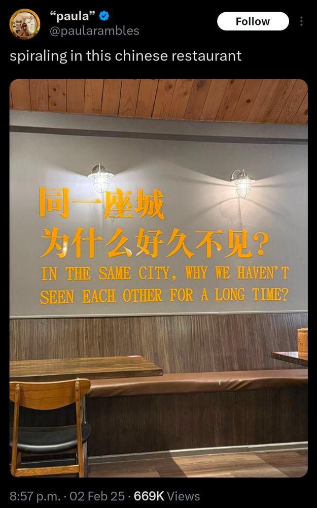 The interior of a Chinese restaurant with yellow letters painted on a grey wall that reads "in the same city, why haven't we seen each other for a long time?"

The picture is captioned by user @paularambles and reads "spiralling in this Chinese restaurant"