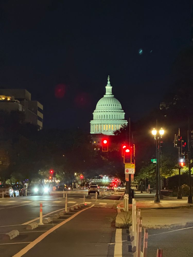 US Capitol dome stands out against a dark night sky. An annoying collection of red stoplights shine below, perhaps indicative of the general state of things up the Hill.