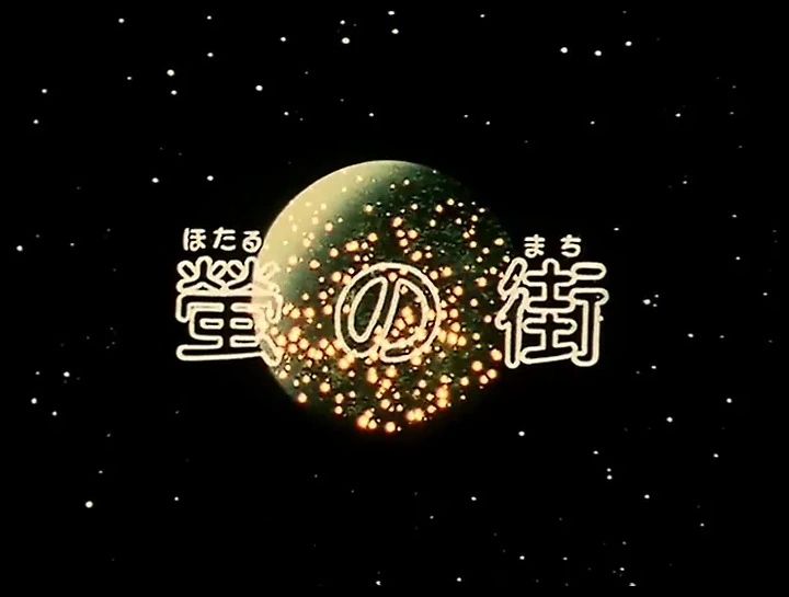 The opening title card of Galaxy Express 999 episode number 16, "The Town of Fireflies". The picture shows a starfield in space, with a green planet in the center, covered in flickering golden lights. The episodes title is laid on top of this image.