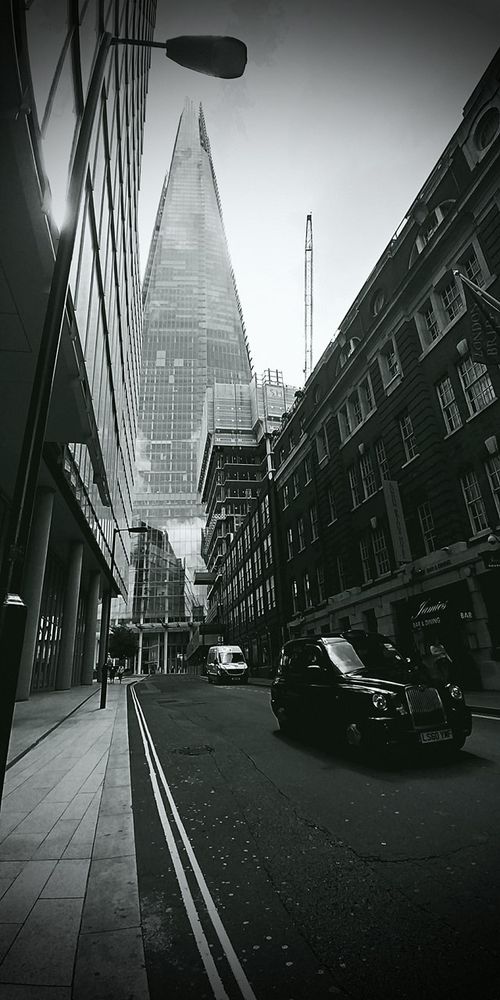 Rue de londres , un taxi noir, un gratte ciel dans les nuages