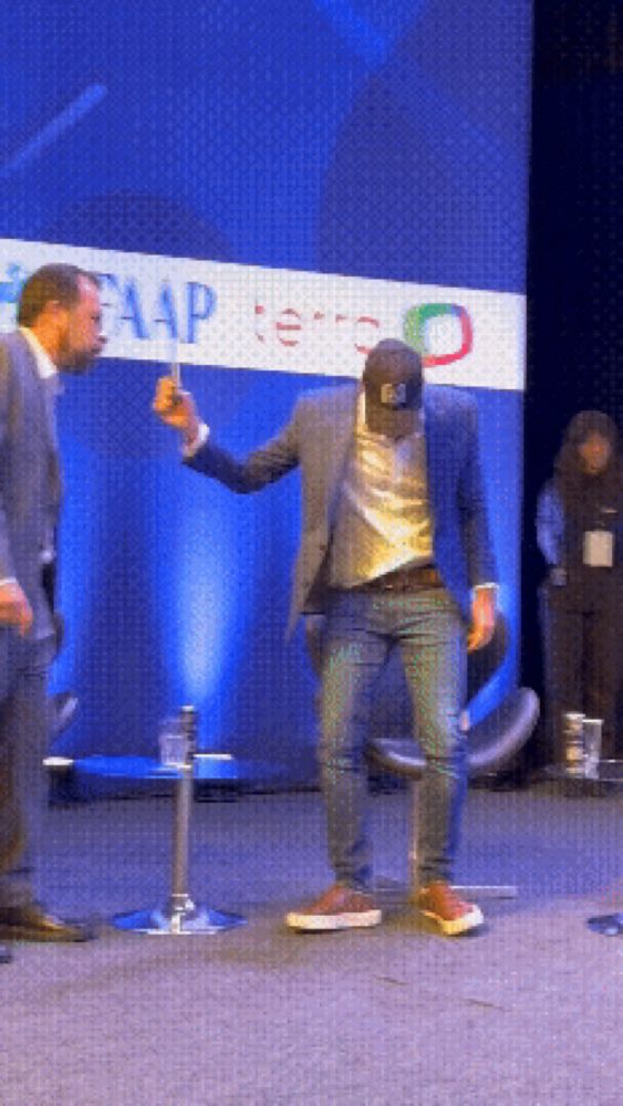 a man is dancing in front of a sign that says aap