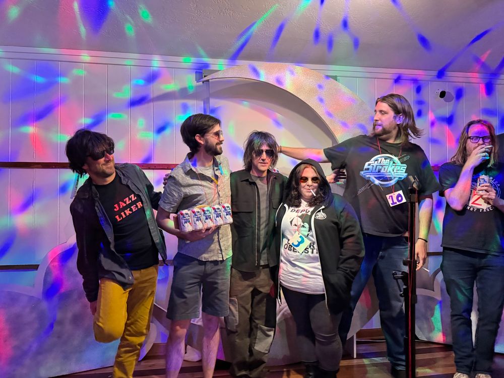 Contestants at the Conor Oberst lookalike contest pose on stage with Conor himself in the middle