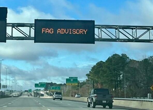 A road sign on a highway that reads "FAG ADVISORY"