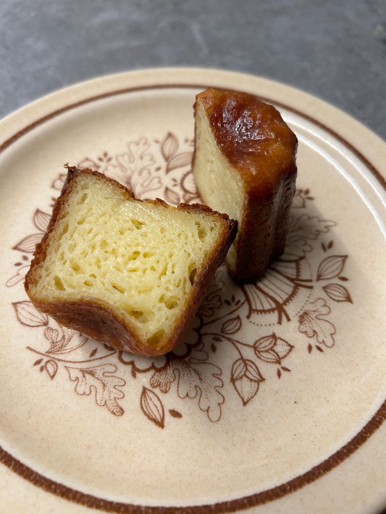 A canelé cut in half - the inside is yellow and kinda squishy.