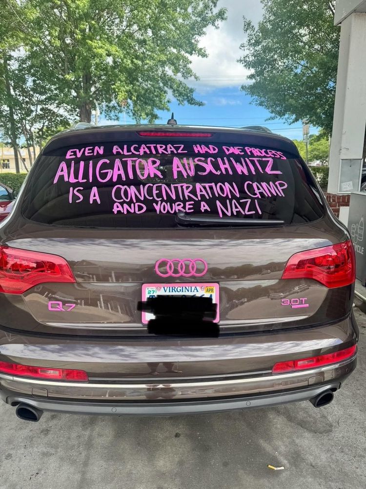 Back window of car with handwritten words in pink: Even Alcatraz had due process. Alligator Auschwitz is a concentration camp and you're a Nazi.