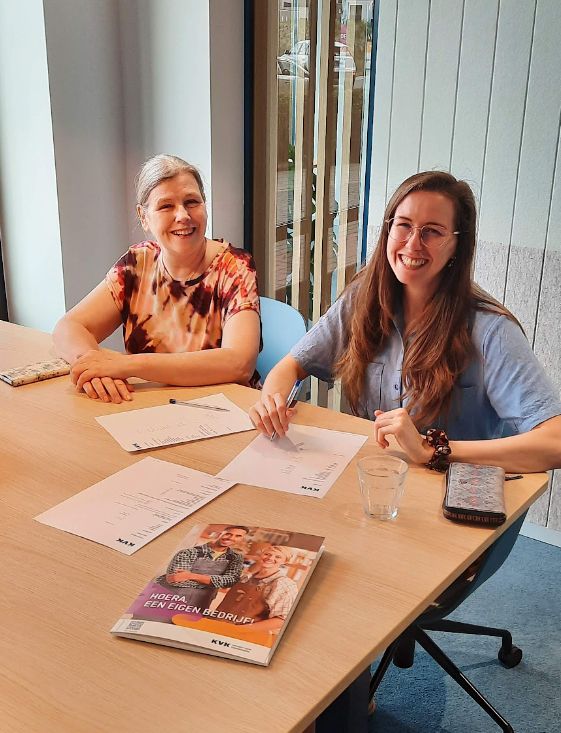Me, Sacha, and my mom,sitting at a table with papers in front of us, where I just signed for my own company!