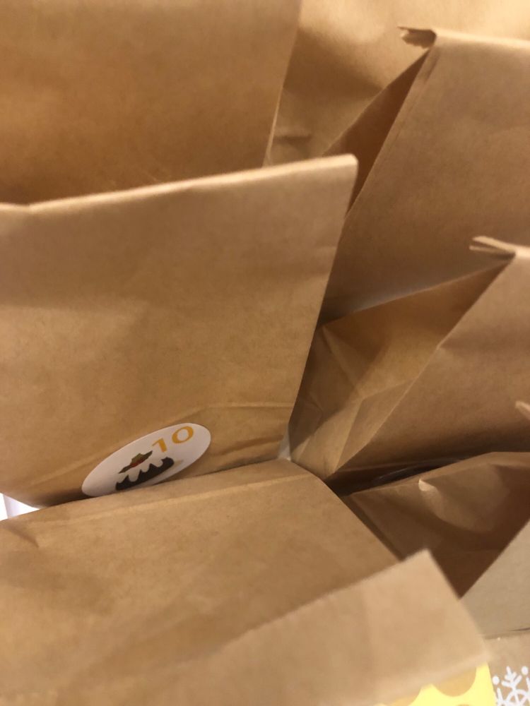 Braune Papiertüten, zugeklebt. Auf einer sieht man den Zahlenaufkleber '10'.