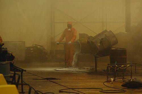 Une personne, en combinaison complète de protection, nettoie le site de l'incendie de Schweizerhalle.