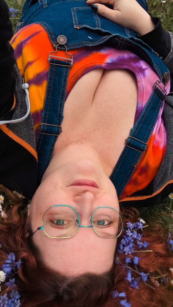 Laying down in the grass with wild flowers in my curly red hair 