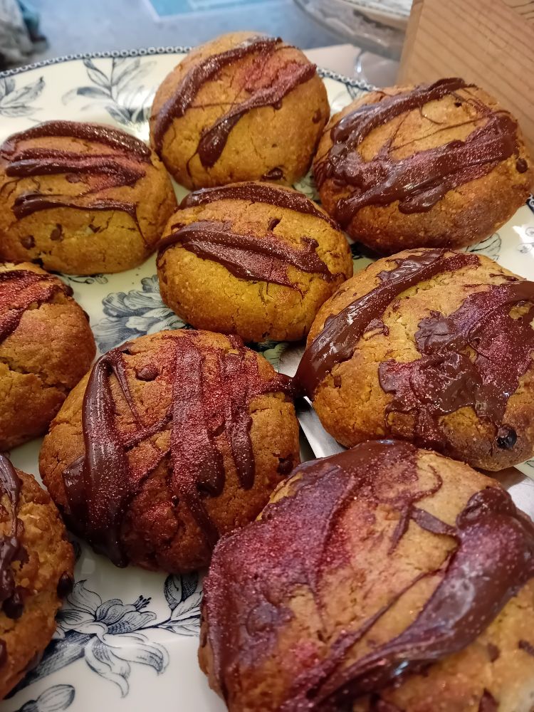 Une assiette de cookies choco noisettes, recouvert de chocolat et de paillettes rouge 