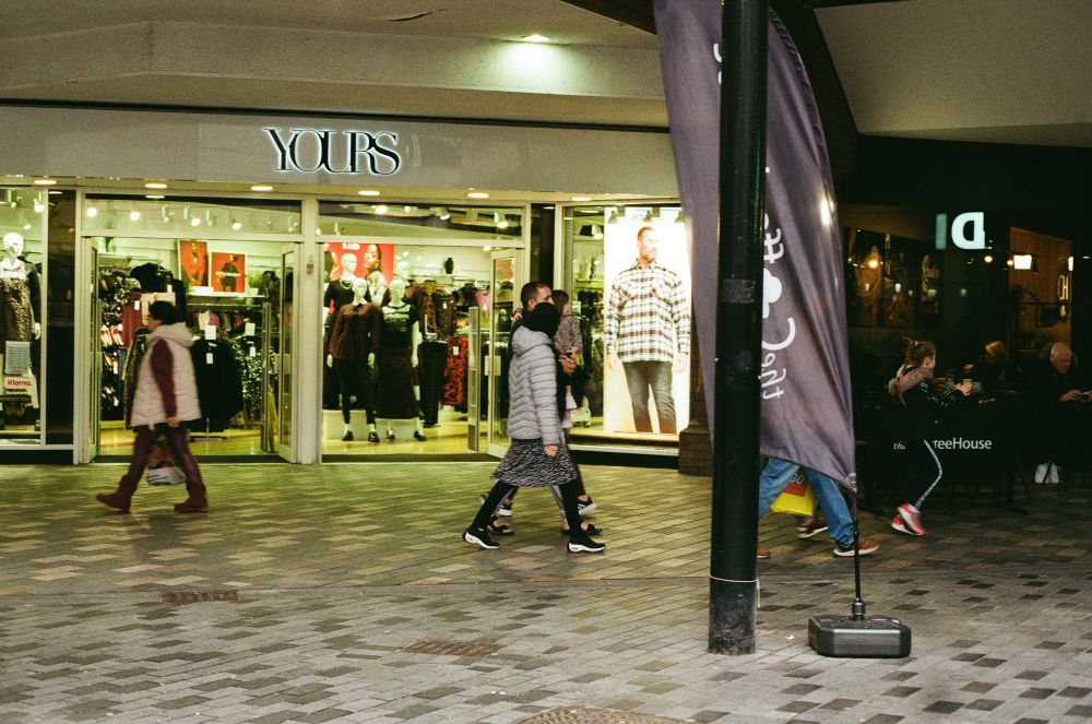 People walking in front of a clothing shop called Yours.