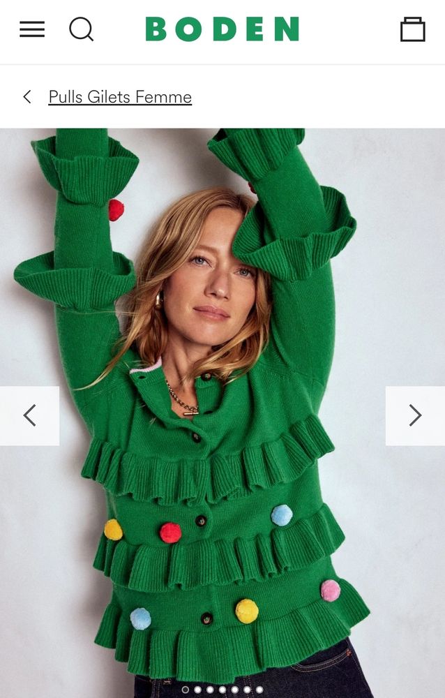 Gilet vert à volants sur le corps et les manches, et des pompons qui symbolisent les boules