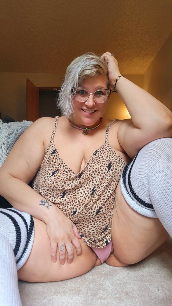 Thick woman in thighs high white socks and leopard print tank top spreading her legs on the floor 