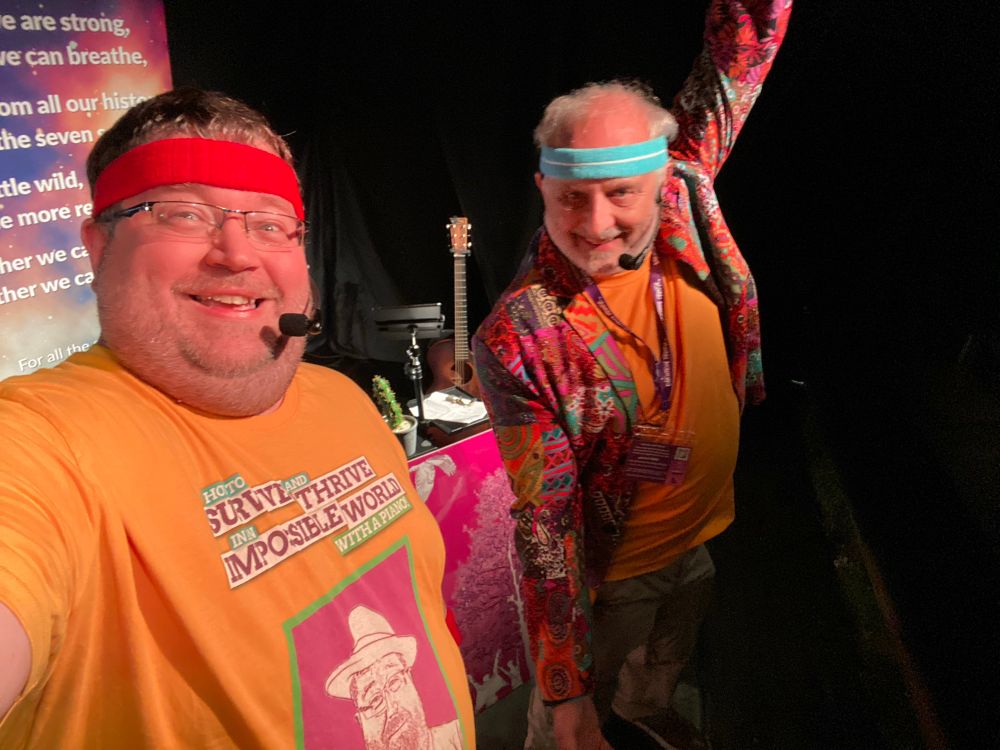 Chris and Steve on stage during HTSAT show - both wearing yellow T-shirts and brightly coloured exercise sweat bands