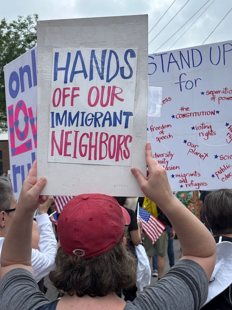 Protest sign reading “Hands off our immigrant neighbors.”