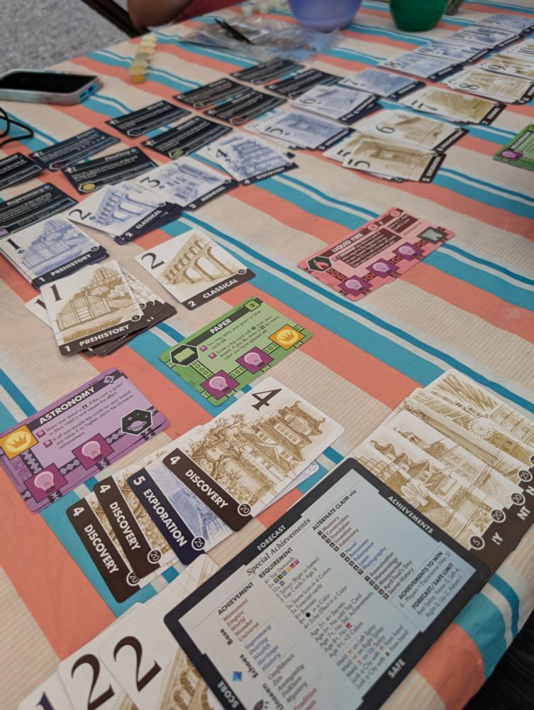 Lots of cards on an ugly tablecloth, but the cards are Innovation Ultimate with the Echoes of the Past expansion