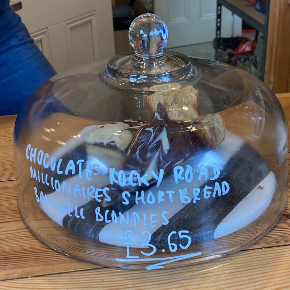 A selection of baked treats on a striped plate under a glass dome 