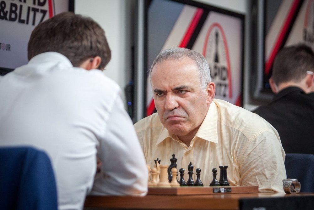 Garry Kasparov's trademark presence at the board. He is pictured here at age 54, retired from serious chess for more than a decade, absolutely glowering at his opponent with his watch removed and placed to the side of the board. Garry sits in a light yellow shirt; his opponent is only pictured from behind and appears to be looking at the board. 

From the picture it's obvious that only a move or two have been played and there is no particular tension in the game, and for him at least, very little is at stake. This is just Kasparov being Kasparov

Source: https://x.com/IM_Rosen/status/897526336025178112