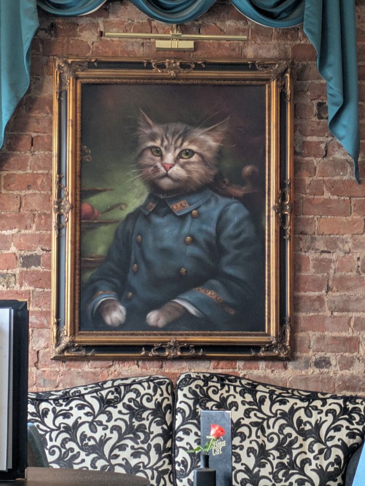 A large painted portrait of a kitten dressed as an officer of the armed forces